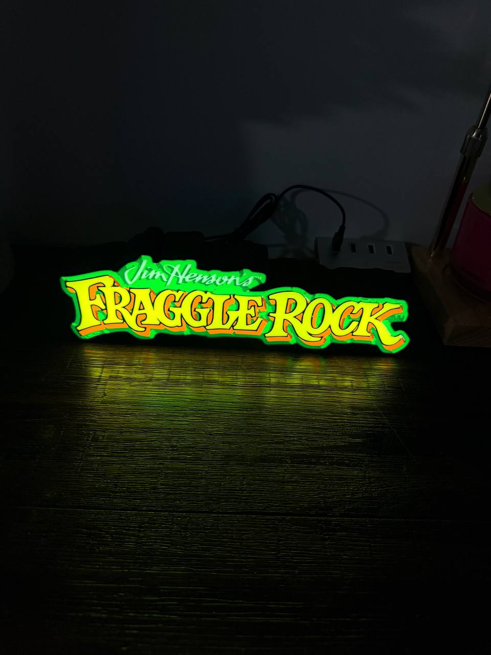 Fraggle Rock LED sign illuminated with green outline — centred front view