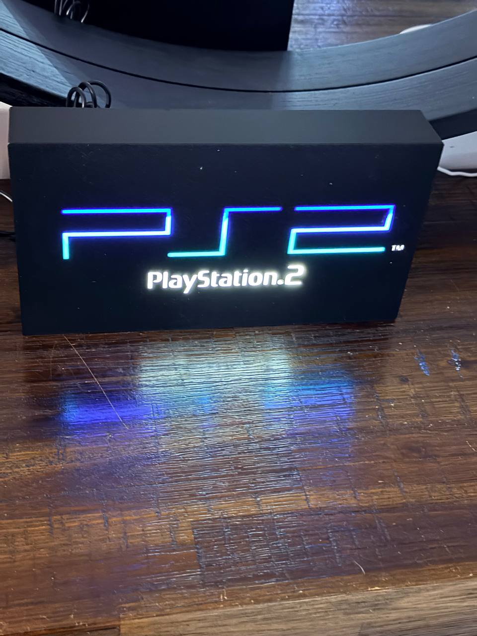 Sony PlayStation 2 LED light-up sign (full PS2 logo + PlayStation.2 text) in original PS2 colours — front view, lit